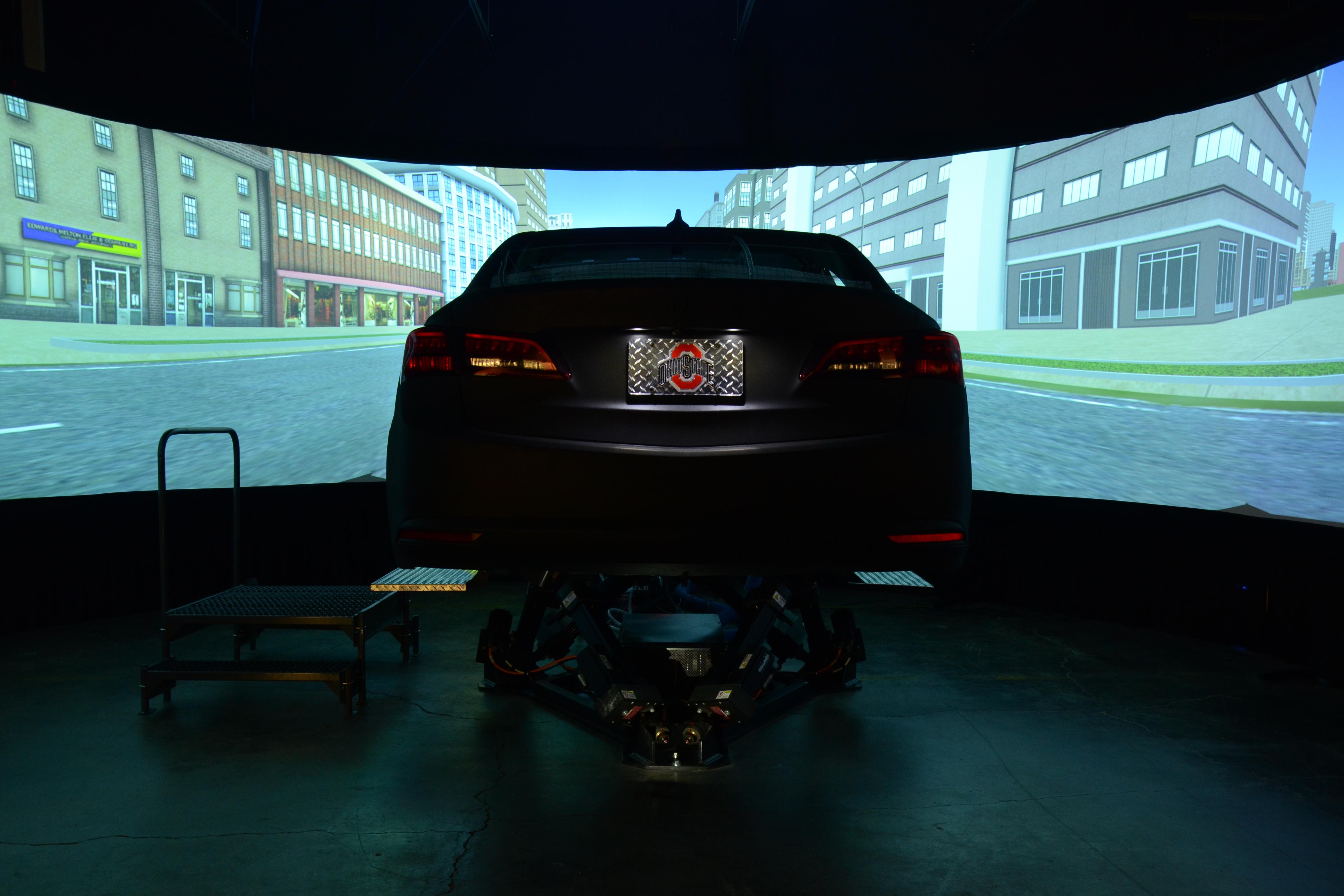 a view of the simulator from behind the vehicle that is facing a panoramic screen