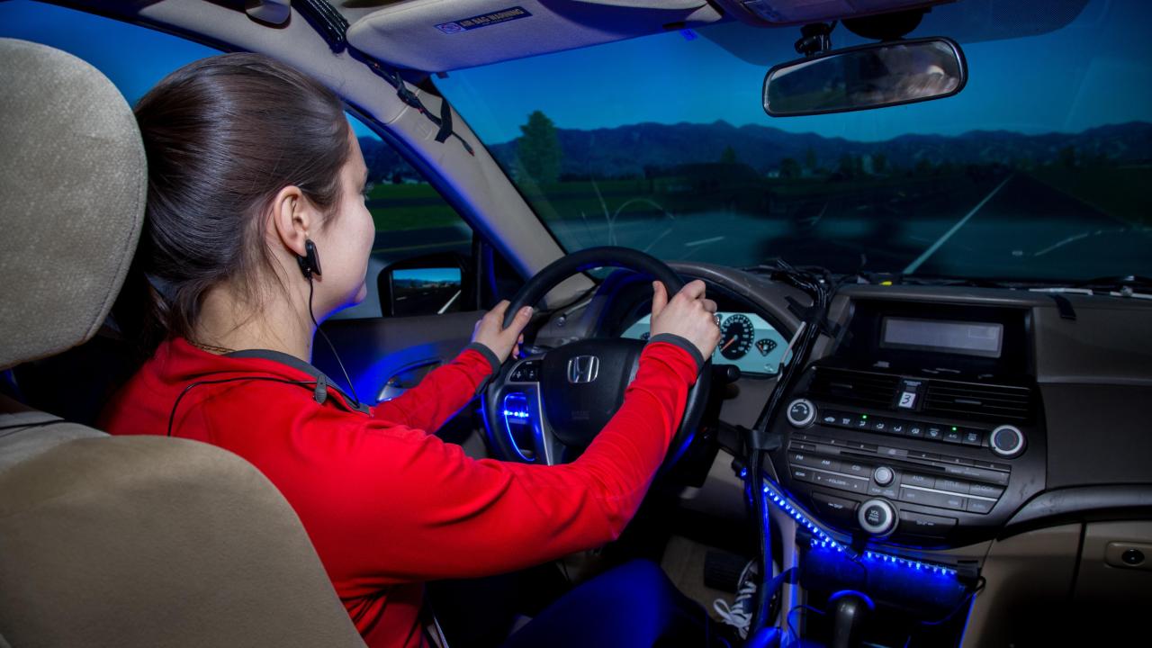 female student wearing red long sleeve shirt participating in the drive sim